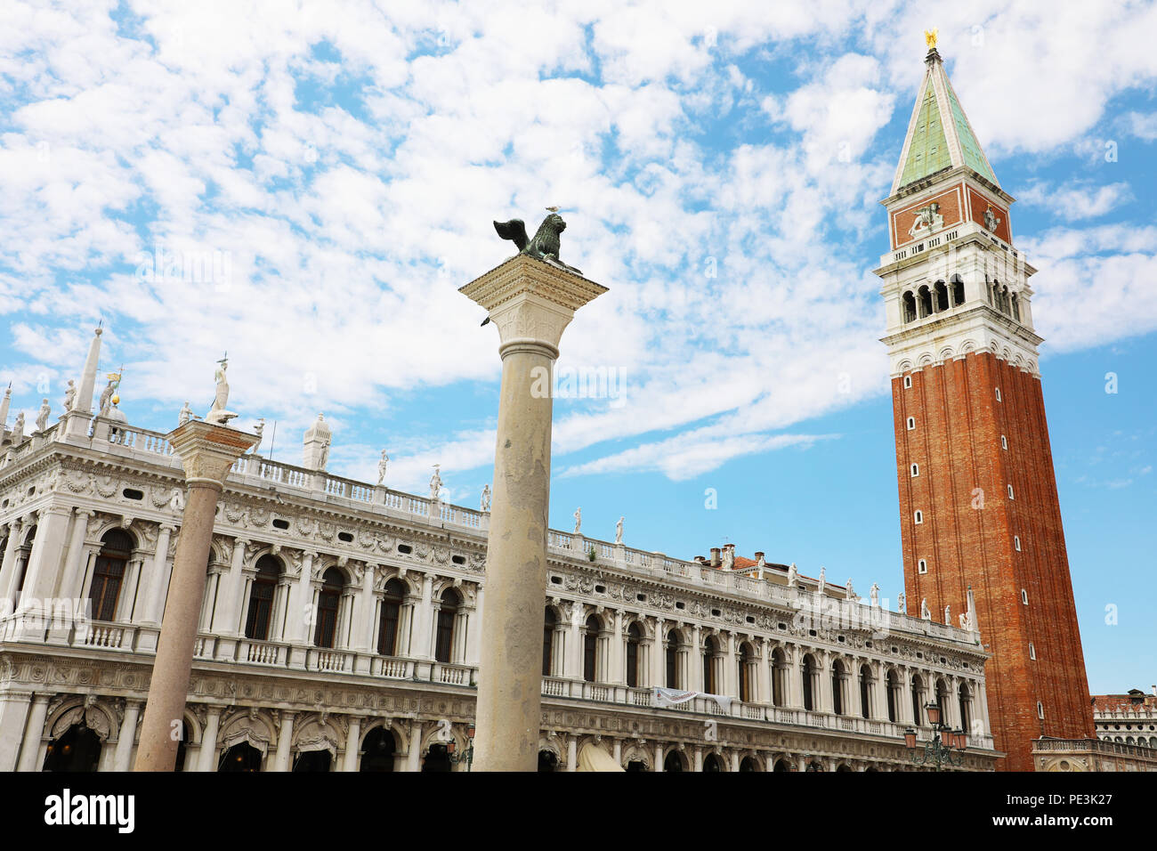 Il bianco delle nuvole nel cielo blu su Piazza San Marco con la torre campanaria e la statua di Lion a Venezia, Italia Foto Stock