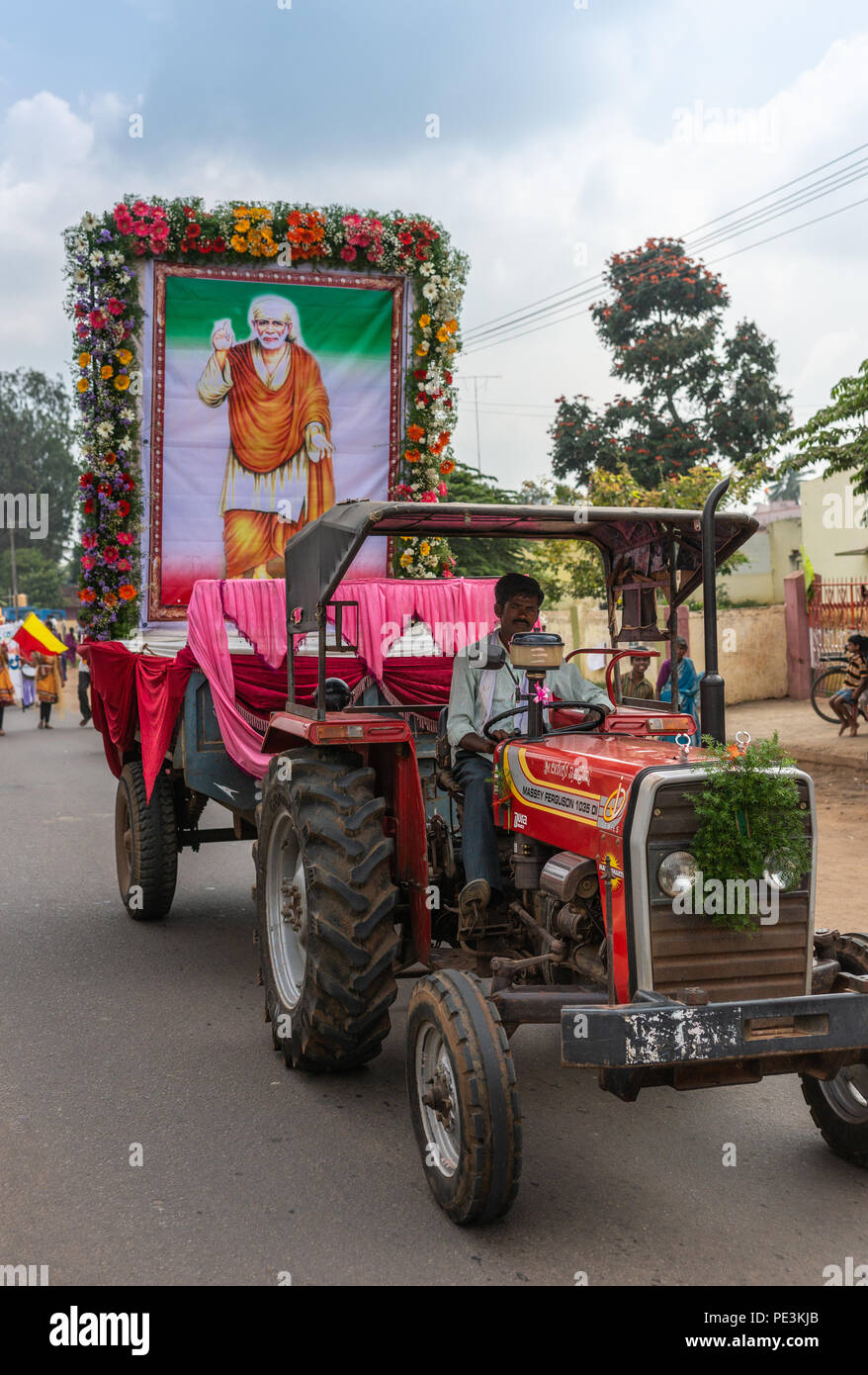 Mellahalli, Karnataka, India - 1 Novembre 2013: Karnataka Rajyotsava Parade. La grande immagine del santo uomo Shirdi Sai Baba tirato da red trattore agricolo. Foto Stock