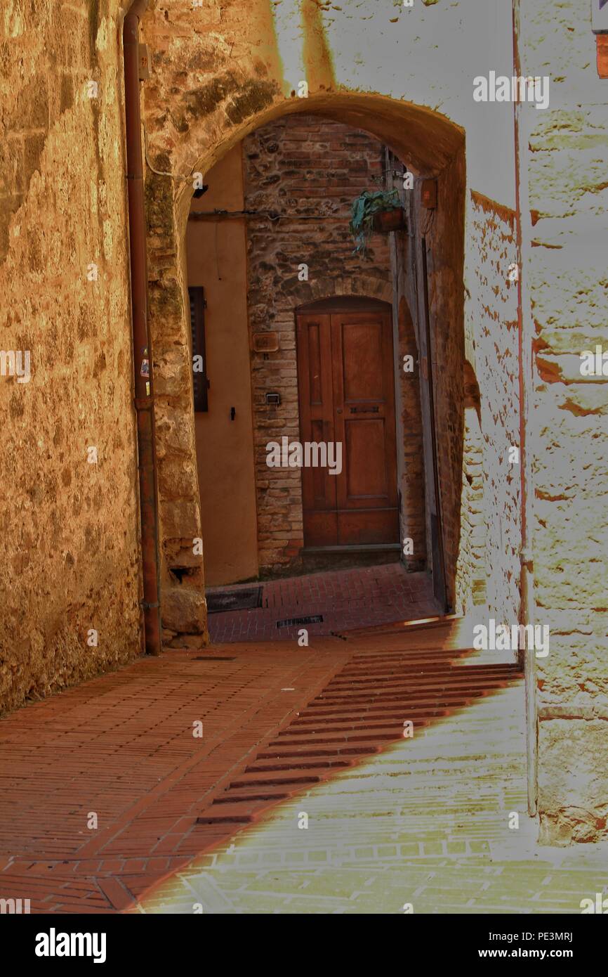 Una porta chiusa alla fine di uno stretto vicolo a San Gimignano, Italia Foto Stock