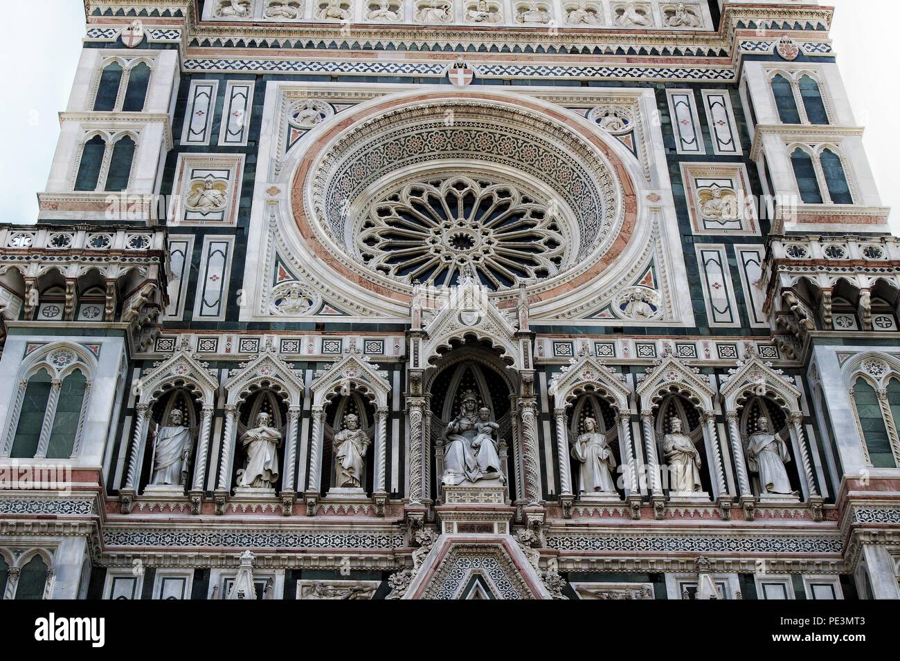 Un basso angolo di visione della facciata e di elementi architettonici e decorativi di Il Duomo di Firenze, Italia Foto Stock