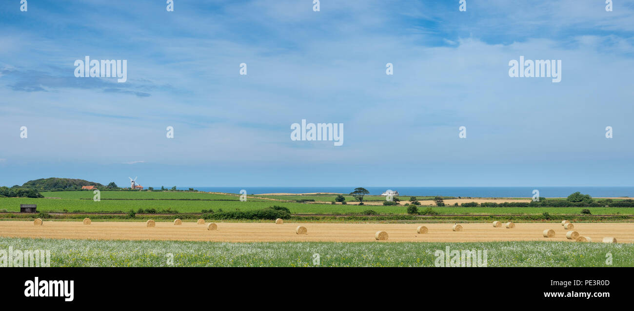 La Costa North Norfolk visto attraverso i campi con il mulino a vento di Weybourne in background. Foto Stock