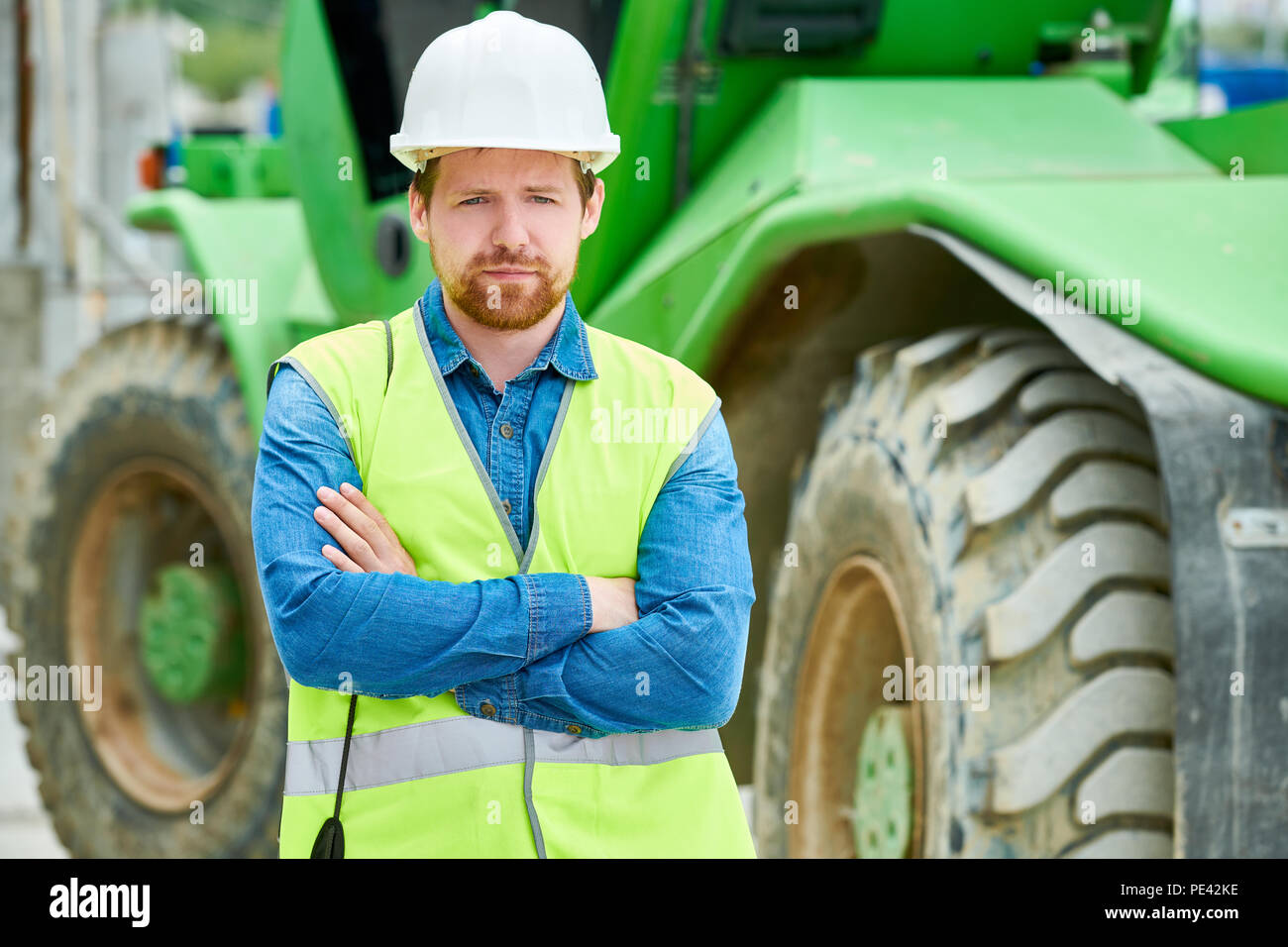 Fiducioso engineer vicino a macchina pesante Foto Stock