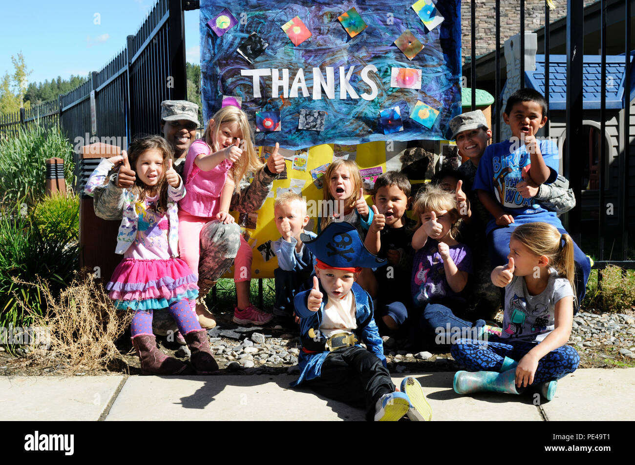 Spc. Brianna Hunter, sinistra, nativo di Atlanta, e il tenente Kelsey Fincher, nativo di Snellville, Georgia, entrambi della Task Force Primo Round, al di fuori della base comune Lewis-Mccorda, posa per una foto con i bambini della Prima Infanzia Centro di apprendimento in Camas centro comunitario situato sulla Kalipsel Indian Reservation, Washington, Sett. 3, 2015. I soldati hanno preso tempo lontano dal fuoco di supporto operazioni di soppressione a visitare la comunità e interagire con alcuni dei bambini. Foto Stock