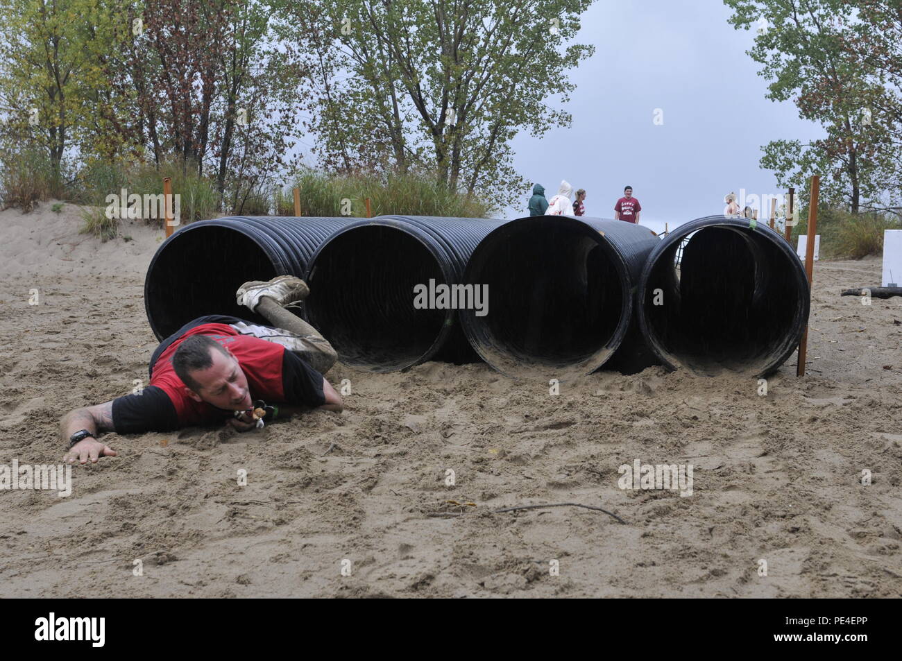 Spc. Brandon Craft, nativo di Erie, Pa. assegnato al 298azienda di trasporti in Franklin, Pa., lotte di emergere da un ostacolo al barbiere bestia sulla Baia su Presque Isle, sabato, Sett. 12, 2015. Dieci chilometri di corsa a ostacoli sollevati i soldi per il Barbiere Istituto nazionale, un'organizzazione che fornisce i servizi di sostegno per i bambini e gli adulti con disabilità. Foto Stock