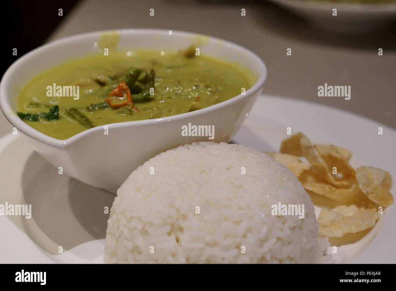 Curry verde tailandese servito con riso Foto Stock