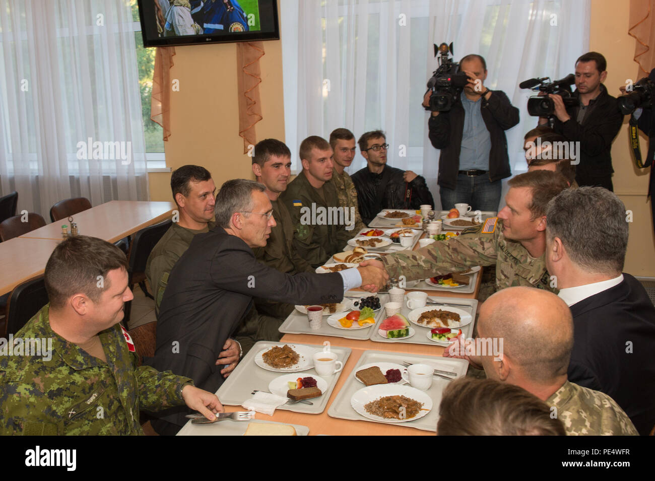 Presidente dell'Ucraina Petro Poroshenko e il Segretario generale della NATO Jens Stoltenberg potrete gustare un pasto con i paracadutisti DA PARTE DEGLI STATI UNITI Dell'esercito 173rd Brigata Aerea, canadese e armate ucraine le forze a livello internazionale per il mantenimento della pace e della sicurezza nel centro Yavoriv, Ucraina, Sett. 20, 2015. I due hanno visitato l'IPSC per iniziare una quattro giorni di emergenza combinato-risposta esercizio di 34 nazioni. I paracadutisti da 173rd Brigata Aerea sono in Ucraina per la terza rotazione al treno Ucraina la neo-costituita la guardia nazionale come parte di intrepida custode, che è programmato per ultimo a novembre. Foto Stock