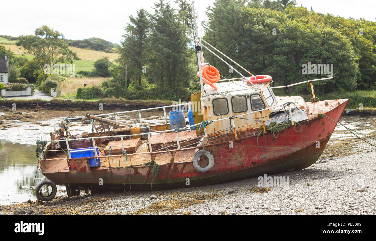 Rusty, arrugginimento nave naufragata hull legato su una insenatura battigia. Foto Stock