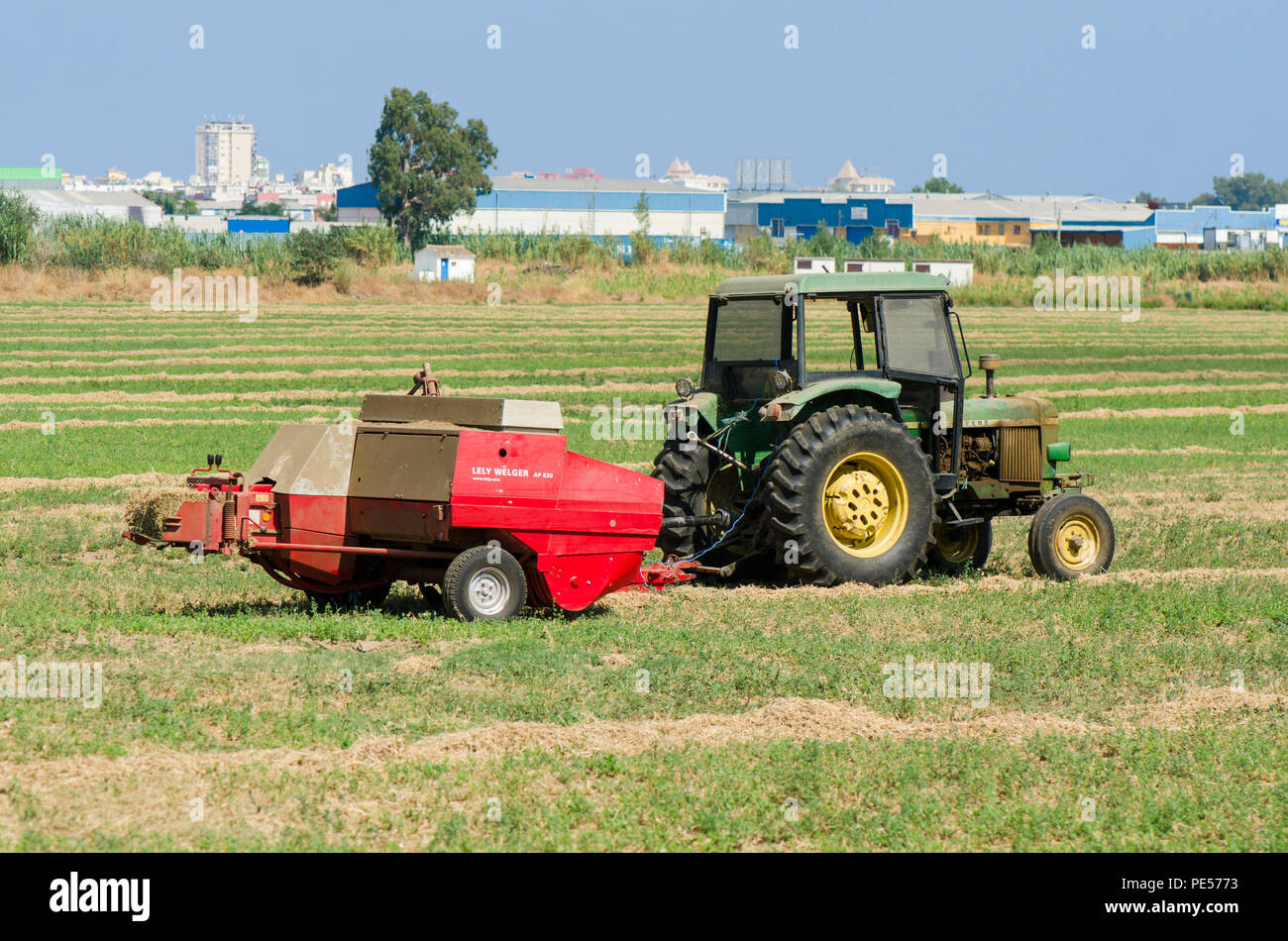 Fienagione rotopressa trattore, fieno macchina imballatrice, macchine agricole, terra di lavoro di imballatura. Foto Stock