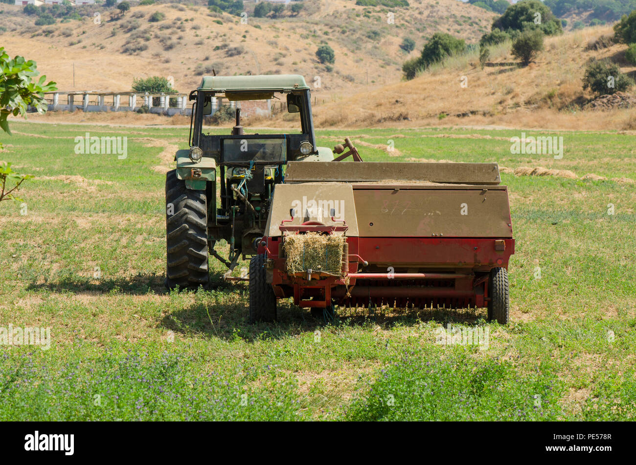 Fienagione rotopressa trattore, fieno macchina imballatrice, macchine agricole, terra di lavoro di imballatura. Foto Stock
