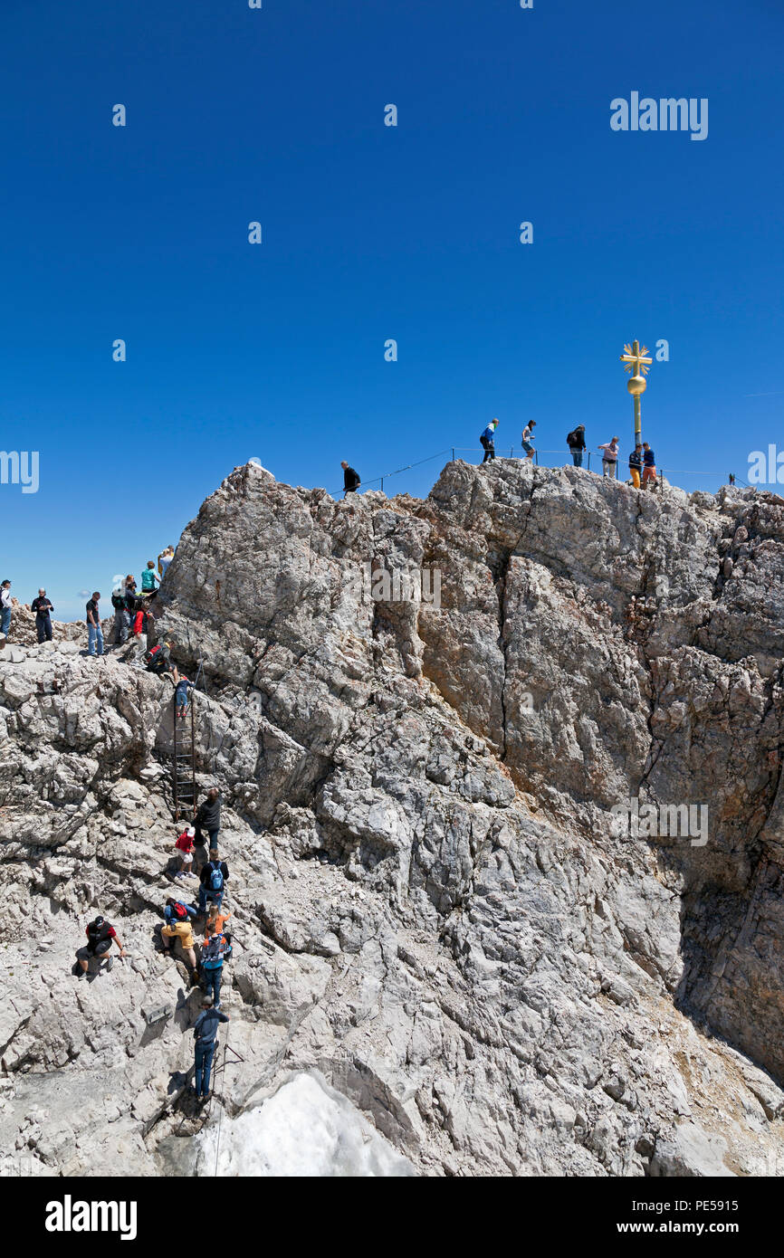 I turisti la scalata al Golden Cross - il punto più alto in Germania sul vertice del massiccio dello Zugspitze a 2.962 m sopra il livello del mare Foto Stock