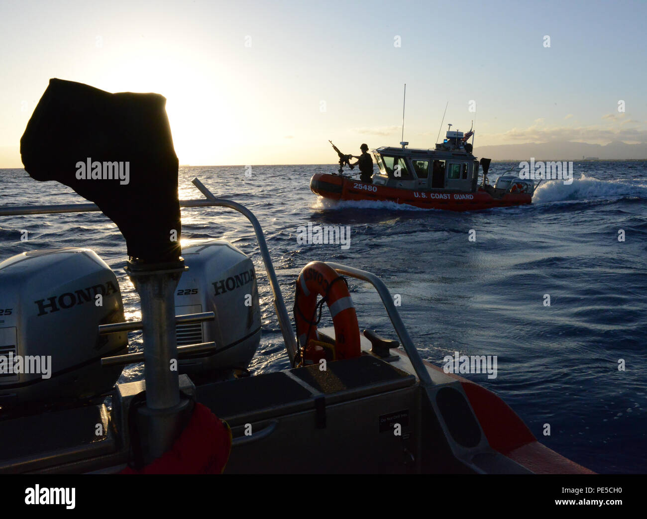 I membri dell'equipaggio a bordo di un 25-piede Boat-Small risposta dalla sicurezza marittima e Security Team 91107 escort la nave da crociera Pride of America al di fuori del Porto di Honolulu, Ottobre 3, 2015. La guardia costiera conduce accompagnatrici di elevata capacità di navi passeggeri al fine di garantire la sicurezza dei passeggeri, la nave e il porto. (U.S. Coast Guard foto di Sottufficiali di terza classe Melissa E. McKenzie/rilasciato) Foto Stock