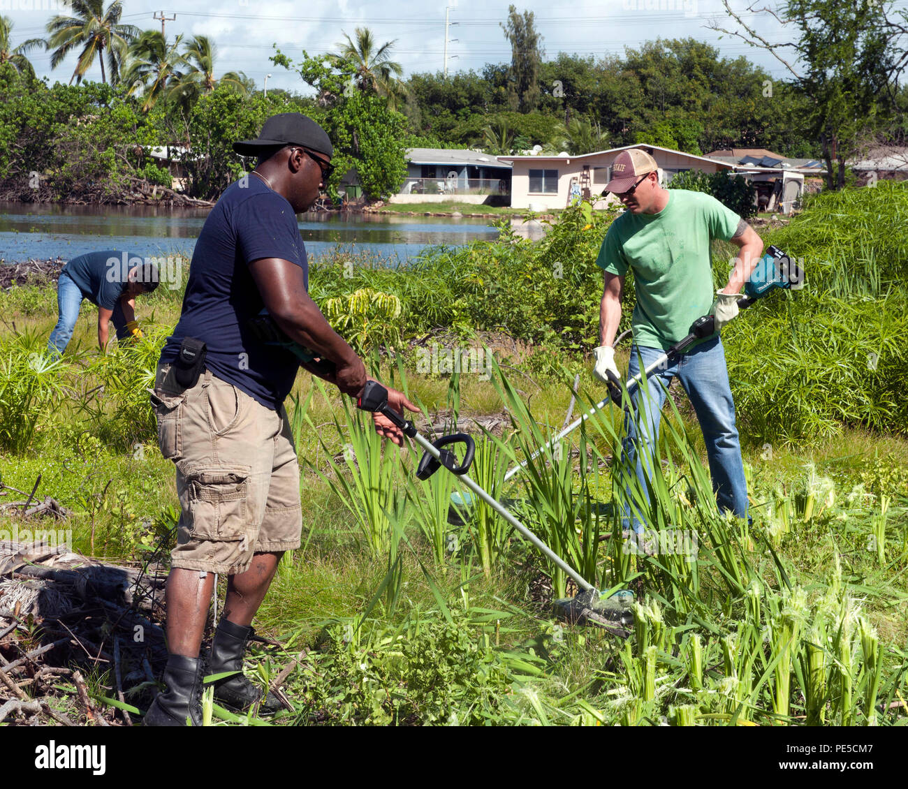 151003-N-SU468-054 PEARL HARBOR (ott. 3, 2015) Il programma religioso specialista di terza classe Brandon Mitchell, sinistra e Staff Sgt. Travis McManus utilizzare weed-whackers per cancellare la vegetazione durante un pubblico nazionale di terre giorno cleanup all'antica peschiera, Loko Pa'aiau, al punto McGrew Navy alloggiamento su Oahu. La peschiera, restauro iniziato a settembre 2014 e è una costante delle risorse culturali il progetto coinvolge la marina e la comunità locale. (U.S. Foto di Marina di Massa lo specialista di comunicazione 2a classe Jeff Troutman/rilasciato) Foto Stock