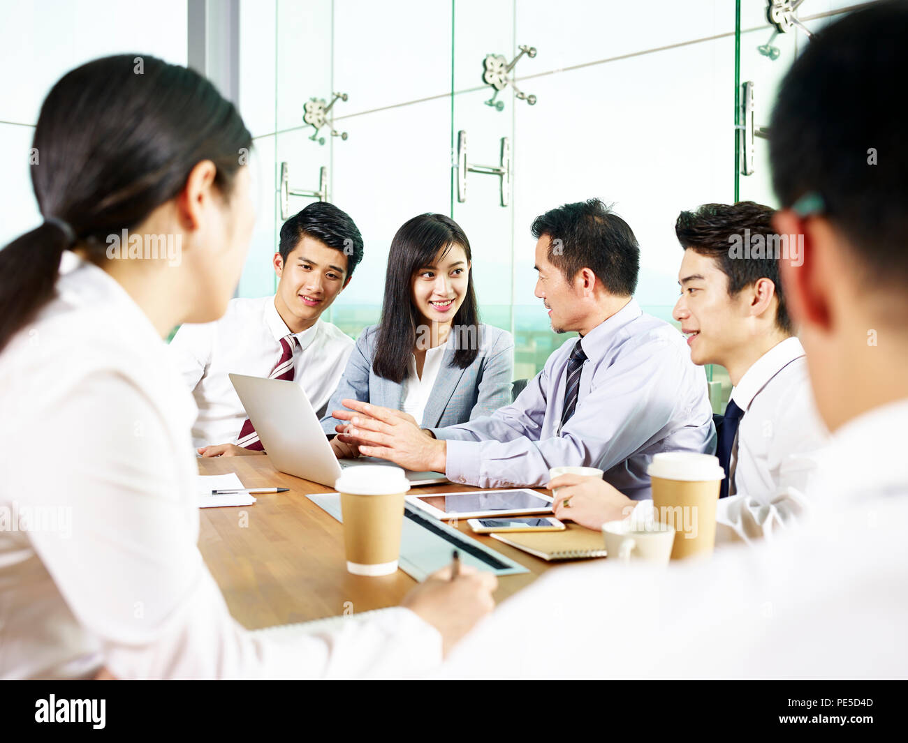 Team di imprenditori asiatici e imprenditrici riunione in ufficio moderno. Foto Stock