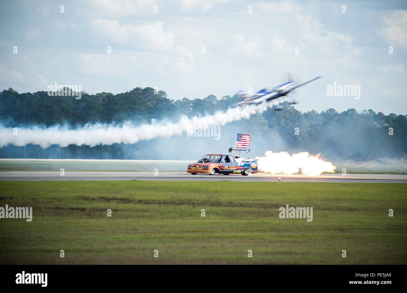 Un aereo acrobatico MXS esegue una dimostrazione di volo sopra il furgone Flash Fire Jet al Thunder Over South Georgia Open House presso la Moody Air Force base, Georgia. L'MXS è un aereo acrobatico monomotore ad alte prestazioni alimentato da un motore Lycoming AEIO-540. Il veicolo Flash Fire Jet è in grado di raggiungere velocità fino a 400 km/h. Le dimostrazioni mettono in evidenza l'aerobatica di precisione, il controllo degli aeromobili e il coordinamento con i display a terra per l'impegno del pubblico. Foto Stock