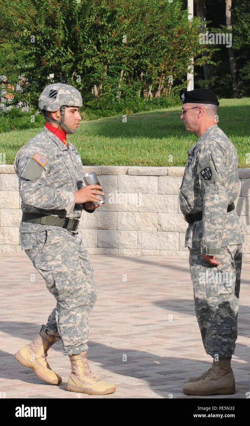 1Lt. Mario Mendez, il responsabile della salute della batteria, 1° Battaglione, decimo campo reggimento di artiglieria, terza divisione di fanteria, presenta l'ultimo scafo cotta per il Mag. Gen. Bryan R. Kelly, in uscita il comandante generale della riserva di esercito Comando medico, durante un cambio del comando cerimonia sett. 26, 2015 a C.W. Bill giovani forze armate centro di riserva a Pinellas Park, Fla. Kelly va in pensione dopo 26 anni di servizio militare e i piani di trascorrere più tempo con la sua famiglia e continuare la sua carriera civile come psicologo clinico vicino alla sua città natale di East Sandwich, messa. Foto Stock