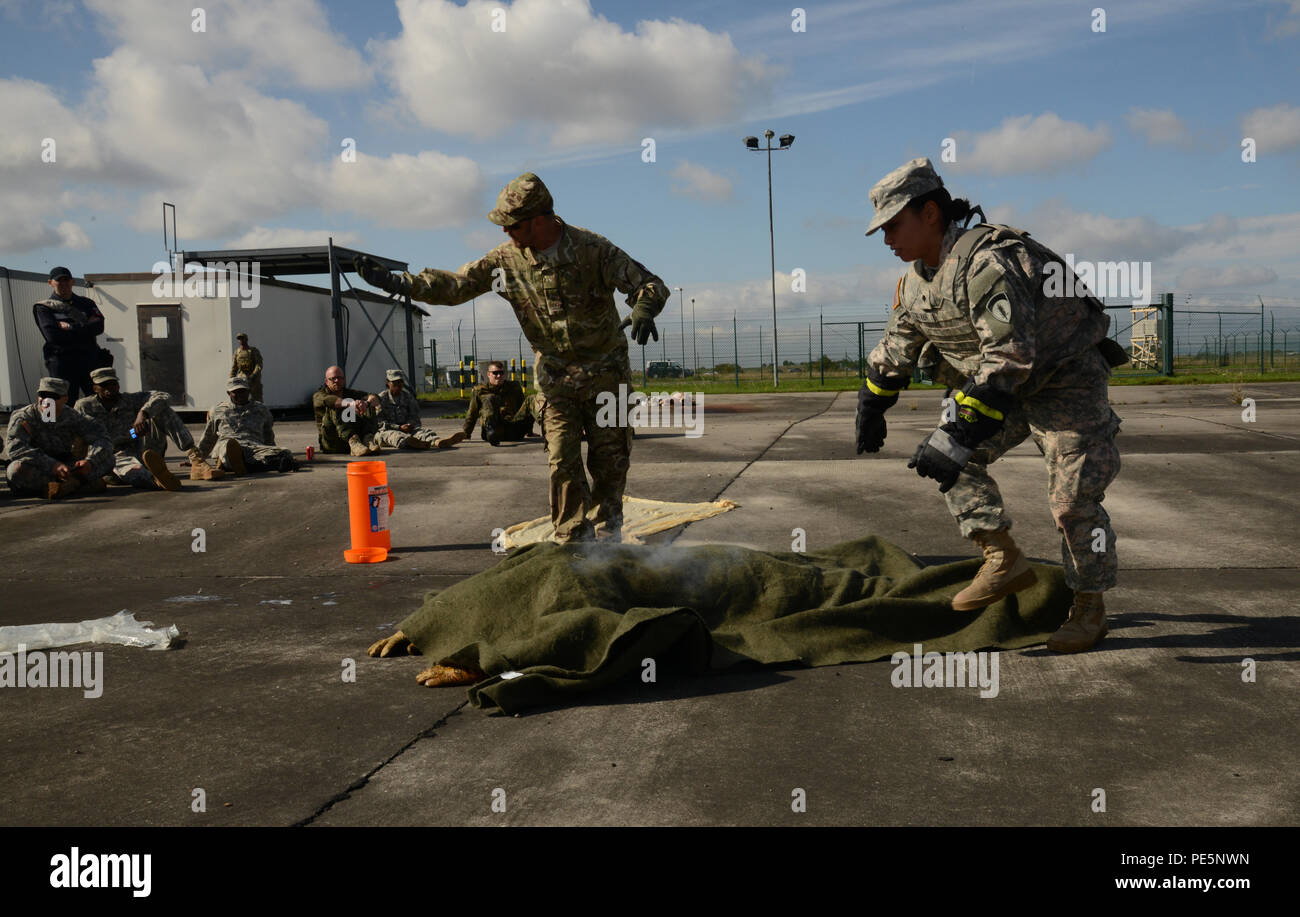 Istruttore Tim Cranton le chiamate più volontari per assistere Spc. Vanessa Nguyen, con USAREUR HHBN (acceso), opera una scena simulata per assistere una vittima che era sul fuoco durante il corso di formazione la lotta internazionale Lifesavers corso tenuto sett. 24, 2015, presso l'area formazione in Finthen, Germania. (U.S. Esercito Foto di Visual Information Specialist Dee Crawford/rilasciato) Foto Stock