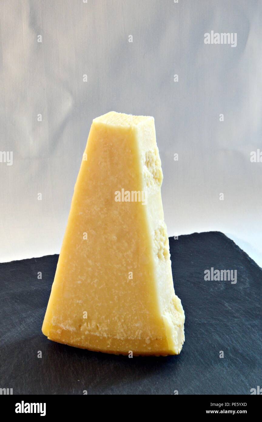 Pezzo di formaggio grana padano su ardesia plain Foto Stock