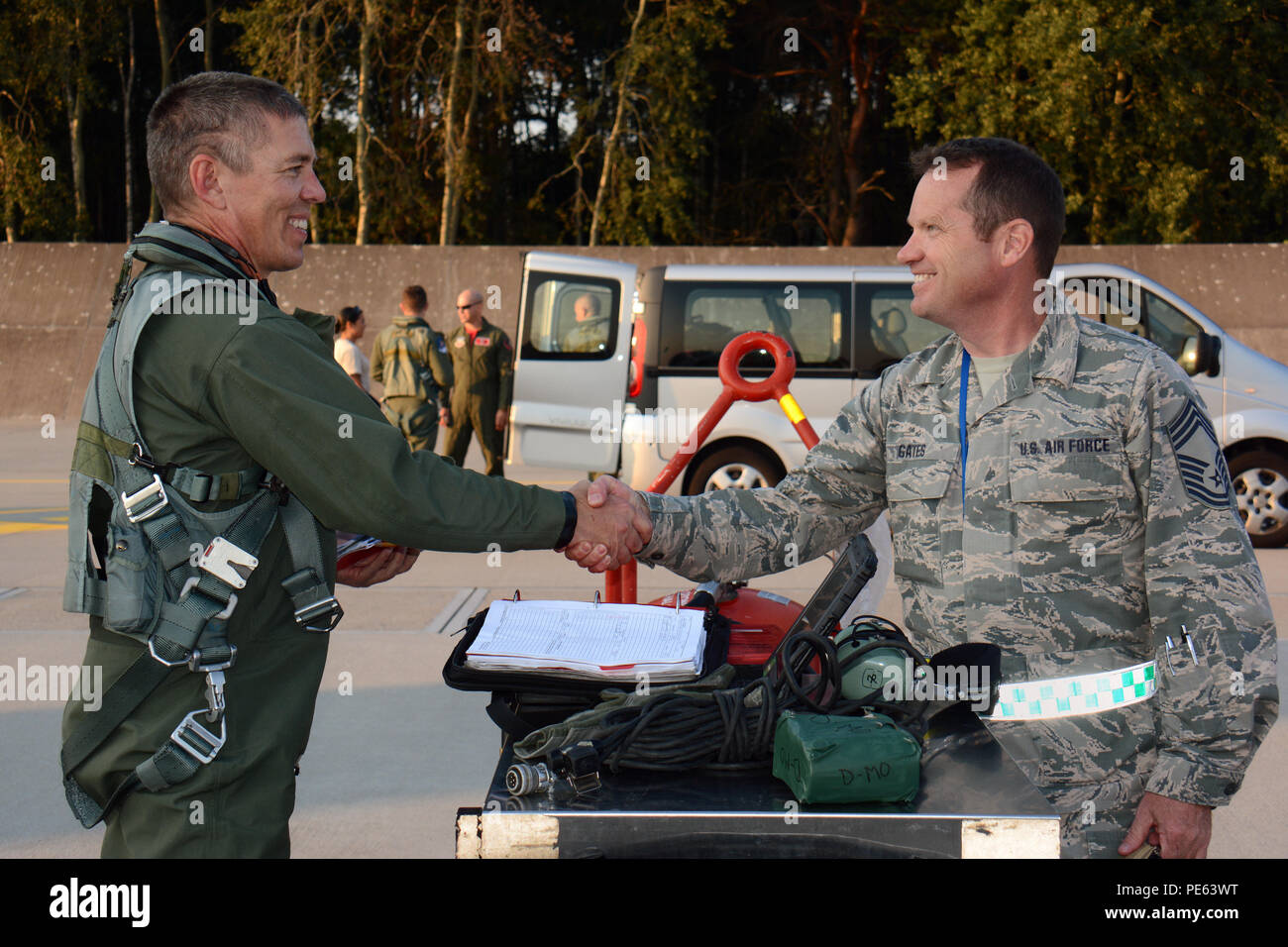 Stati Uniti Air Force Chief Master Sgt. Thomas Gates, manutenzione aeromobili Soprintendente per il Wisconsin Air National Guard's 115Fighter Wing saluta U.S. Air Force Lt. Col. Matteo McCunn, un 176Fighter Squadron F-16 Fighting Falcon fighter aircraft pilota, al momento del suo arrivo a Łask Air Base, Polonia, Sett. 4, 2015. Il Wisconsin aviatori si uniscono a loro servizio attivo omologhi 52nd Fighter Wing a Spangdahlem Air Base, Germania al treno con il polacco della Air Force durante la U.S. Il distacco di aviazione rotazione 15-4. La formazione annuale esercizio ospitato dal Av-Det è progettato per migliorare bilat Foto Stock