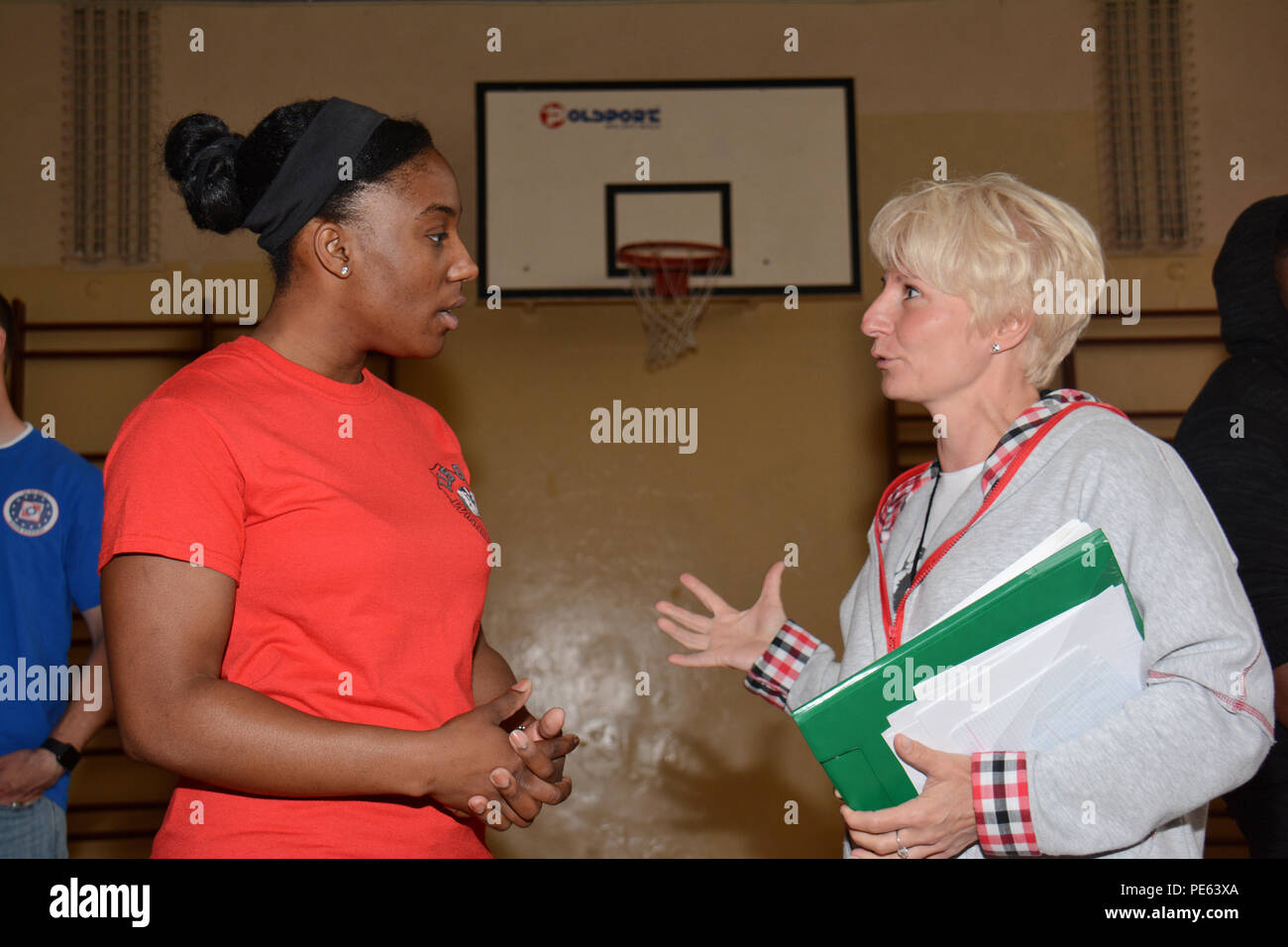 Stati Uniti Air Force Tech. Sgt. Chariann Aghè, aviazione resource manager con il Wisconsin Air National Guard's 115Fighter Wing, si impegna in conversazione con l'educazione fisica istruttore presso Gimnazjum nr 1 middle school in Konstantynów Łódzki, Polonia, Sett. 11, 2015. Aghè hanno contribuito a facilitare lo scambio culturale con la scuola del gli studenti e i docenti mentre distribuito come supporto di U.S. Il distacco di aviazione rotazione 15-4 a Łask Air Base. Attraverso la guardia nazionale dello Stato del programma di partenariato, il 115Fighter Wing ha stabilito un rapporto permanente con il decimo Fighter Squadron a Łask, Foto Stock