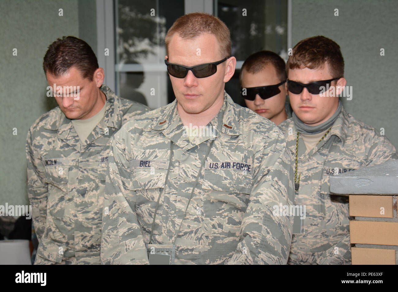 Stati Uniti Air Force 2 Lt. David Biel, centro ufficiale di manutenzione con il Wisconsin Air National Guard's 115Fighter Wing, unisce i compagni di elementi unitari dispiegato per Łask Air Base, Polonia, a sostegno degli Stati Uniti Il distacco di aviazione 15-4 per un momento di silenzio nel proprio 8:46 a.m. Sett. 11, 2015, in ricordo di coloro che hanno perso la vita nel sett. 11, 2001, gli attacchi terroristici. (U.S. Air National Guard Foto di Master Sgt. Paul Gorman/rilasciato) Foto Stock