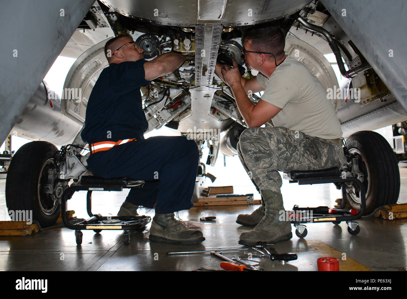 Stati Uniti Air Force Tech. Sgts. Michael Schmidt, sinistra e Alex bianco, manutenzione aeromobili specialisti con il Wisconsin Air National Guard's 115Fighter Wing, sostituire l'accessorio scatola ingranaggi di trasmissione di una delle unità di F-16 Fighting Falcon degli aerei da caccia a Łask Air Base, Polonia. Il Wisconsin aviatori si uniscono a loro servizio attivo omologhi 52nd Fighter Wing da Spangdahlem Air Base, Germania, al treno con il polacco della Air Force durante la U.S. Il distacco di aviazione rotazione 15-4. La formazione annuale esercizio ospitato dal Av-Det è progettato per migliorare la difesa bilaterali i legami tra la Polonia Foto Stock