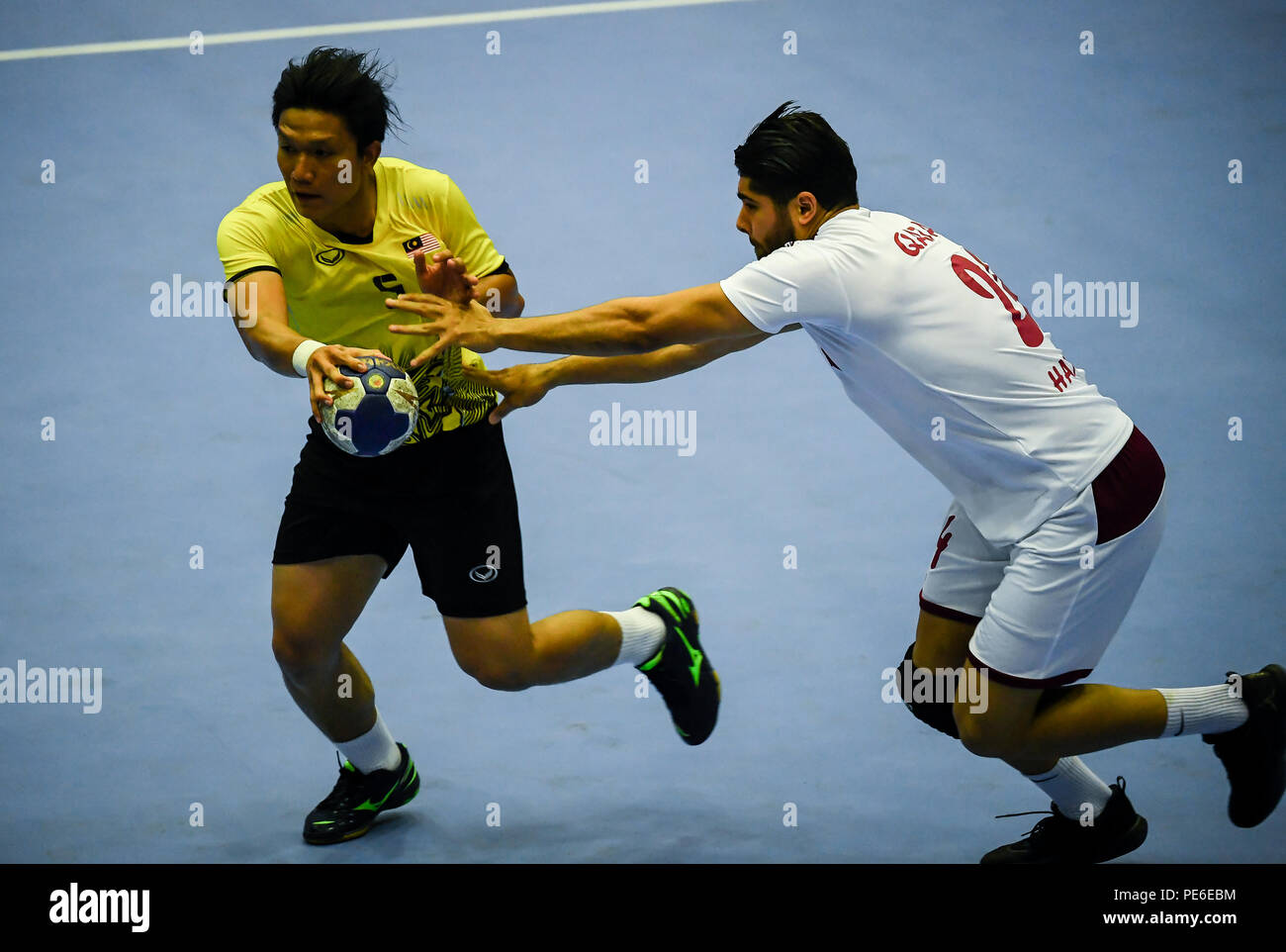 (180813) -- JAKARTA, Agosto 13, 2018(Xinhua) -- Fazrin Jamaluddin (L) della Malesia compete durante il primo turno di gioco di pallamano tra Malesia e Qatar a Giochi Asiatici 2018 a Jakarta, Indonesia, Agosto 13, 2018. Il Qatar ha vinto 64-11. (Xinhua/Li Xiang) Foto Stock