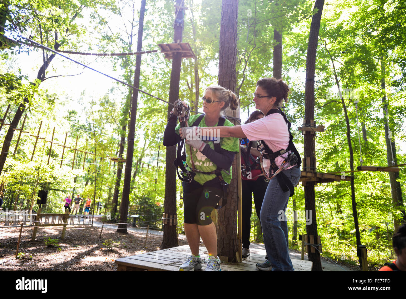 VIRGINIA BEACH, Va. (Ottobre 08, 2015) - I partecipanti del Navy Informazioni forze dominanza Senior Leadership Development Program (SLDP) assistere un altro come si preparano a "zip" attraverso una zip line durante una giornata di abilità-building evento presso il parco avventura a Virginia Aquarium, Virginia Beach, Va. Il giorno di abilità-costruzione di evento è parte di un 10-corso mensile basato sull'Ufficio di gestione del personale (OPM) cinque Core Executive Qualifiche: guidare il cambiamento, portando la gente, risultati pilotato, acume e creazione di coalizioni. (U.S. Navy foto di Michael J. Morris/RILASCIATO) 151008-N-SV3 Foto Stock