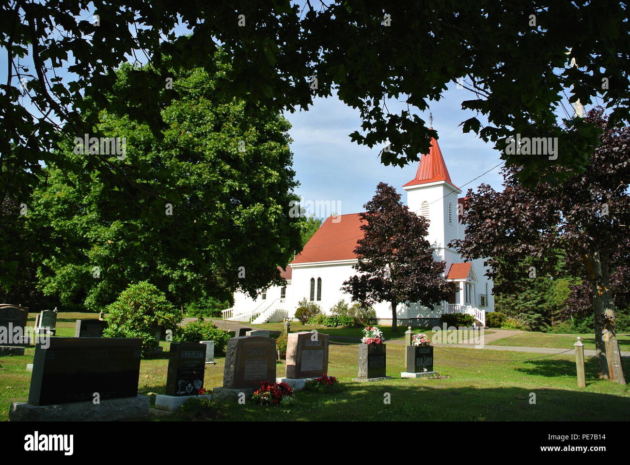 La vista panoramica del centro di Chiesa unita e il cimitero circondato da alberi in una giornata di sole in estate a Dunstaffnage, Prince Edward Island, Canada Foto Stock