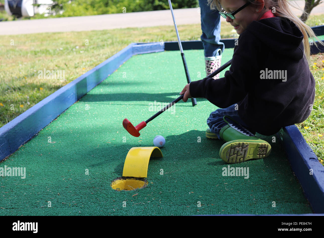 Due bambini giocare mini golf in primavera Foto Stock