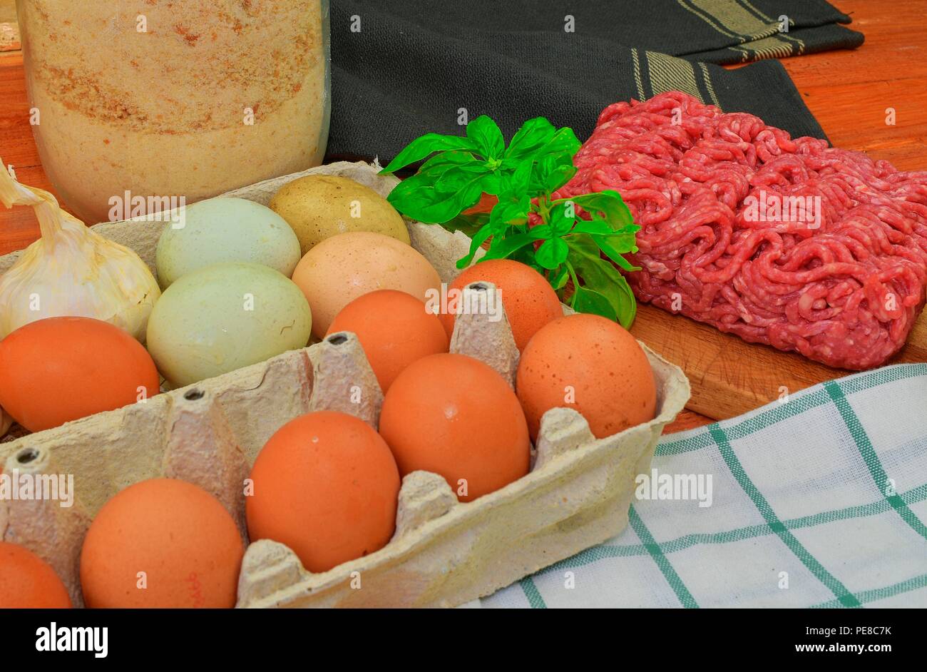 Carni macinate, uova, garlics e cipolla. Carni macinate miste pronto a fare gli hamburger, grassi, meaetballs. Fotografia di cibo. Concetto culinario. La carne macinata ricetta Foto Stock