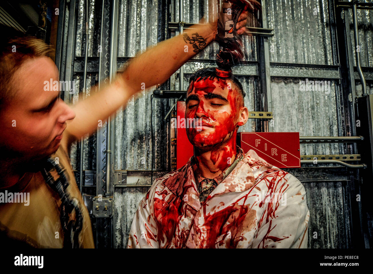 Steelworker 2nd Class applica il trucco di Halloween ad un membro di servizio presso il magazzino infestato CBMU 303 il 23 ottobre 2015, presso Joint base Pearl Harbor-Hickam. I volontari preparano costumi e trucchi per le zone di paura a tema per intrattenere i visitatori. Tutti i proventi vanno a beneficio dell'Hawaii Seabee Ball, sostenendo il morale, il benessere e l'impegno della comunità. L'attività evidenzia l'impegno del CBMU 303 per eventi ricreativi e di comunità sicuri, immersivi e adatti alle famiglie. Foto Stock