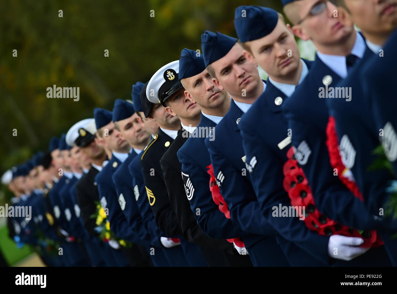 I membri del servizio del Dipartimento della Difesa, portano ghirlande durante il giorno dei veterani cerimonia al Cambridge Cimitero Americano, Regno Unito, nov. 11, 2015. Le corone sono state stabilite in onore i militari del passato e del presente. (U.S. Air Force foto di Master Sgt. Chrissy migliori/rilasciato) Foto Stock