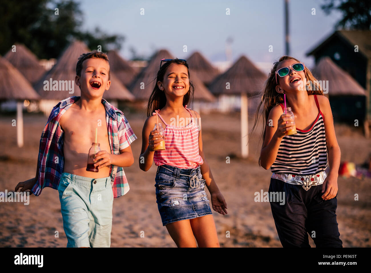 Felice bambini divertirsi mentre si cammina lungo una spiaggia di sabbia. Estate e concetto di viaggio Foto Stock
