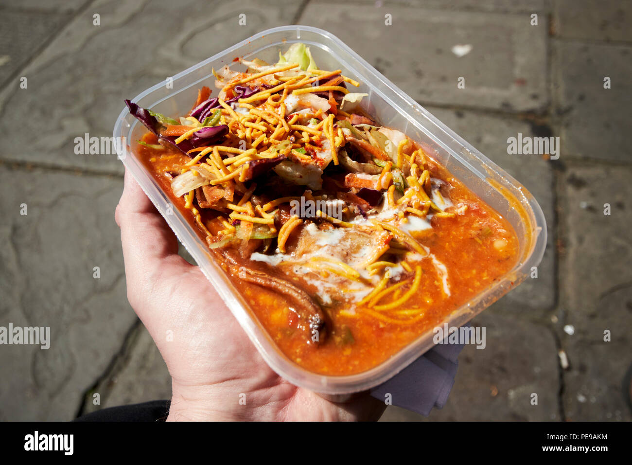 L'uomo azienda indiana vegetariana samosa chaat cibo di strada in un contenitore in plastica nel Regno Unito Inghilterra Bath Regno Unito Foto Stock