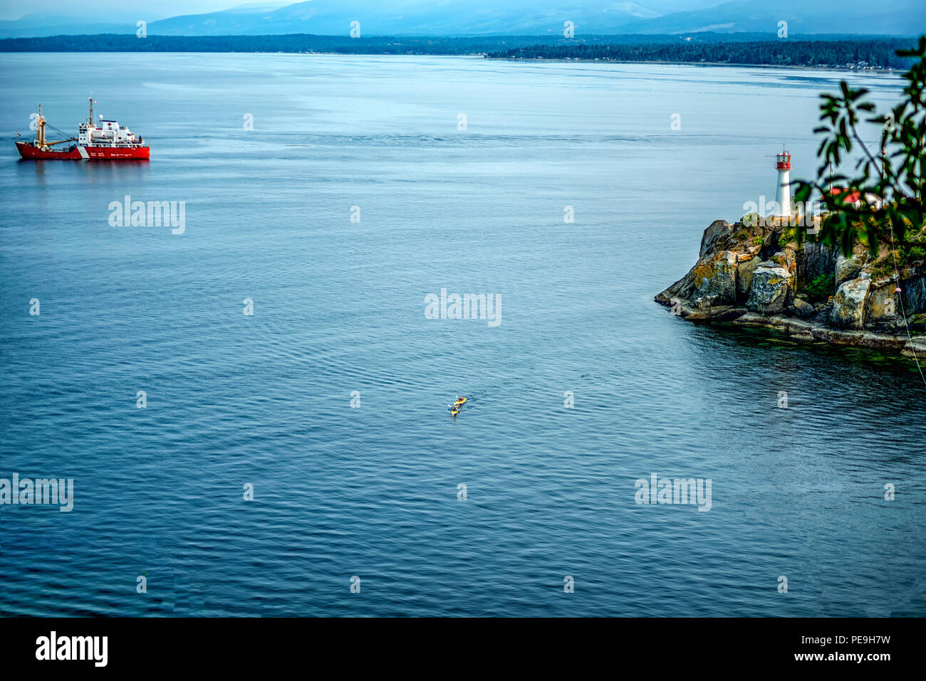 Bellissima Isola di Vancouver Series - Coppia di kayaker passando attraverso vicino a Chrome Island Lighthouse, Denman Island, Canada 3. Foto Stock