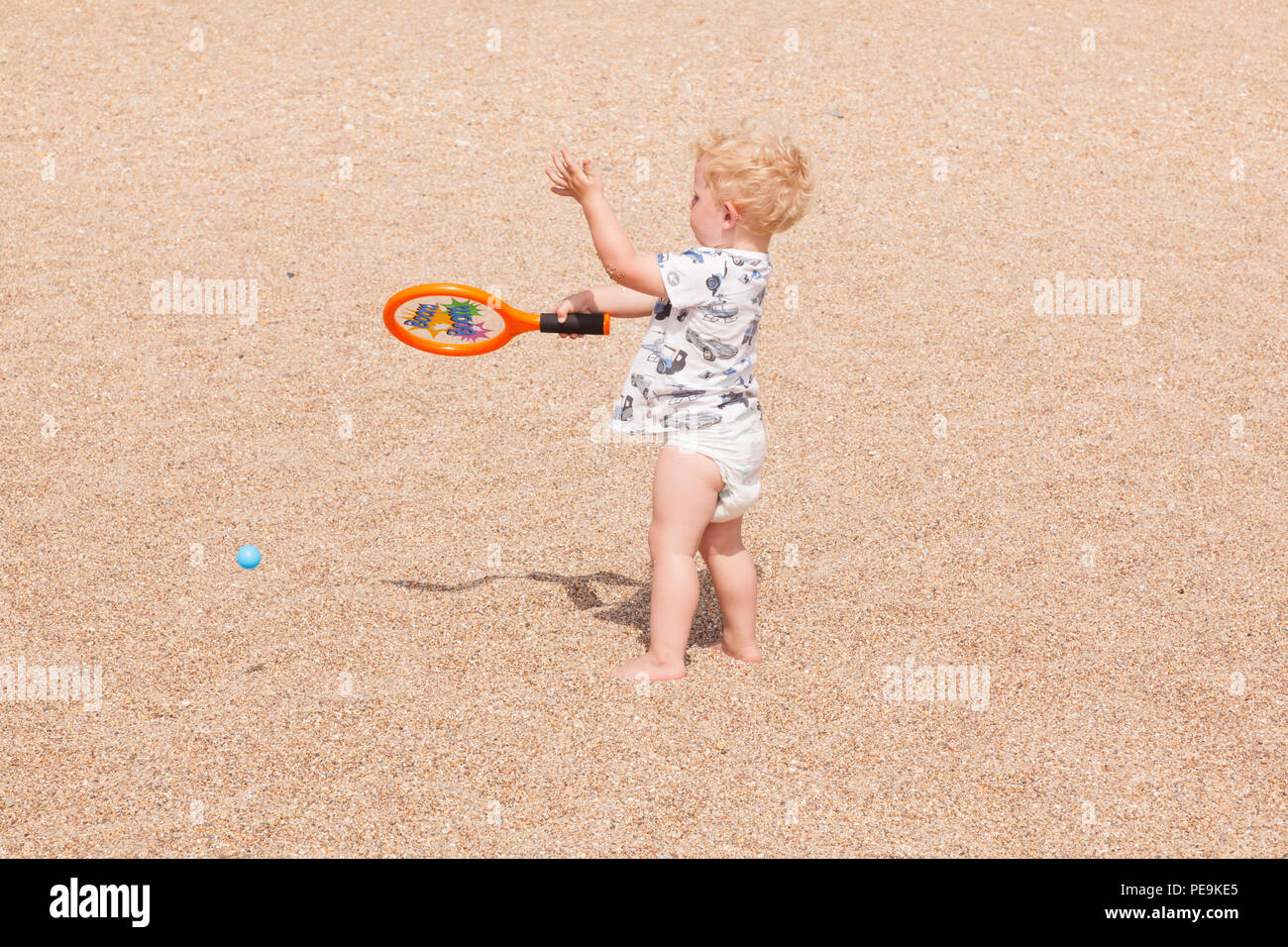 Ragazzo di due anni che gioca con un pipistrello e palla, Devon, Inghilterra, Regno Unito. Foto Stock