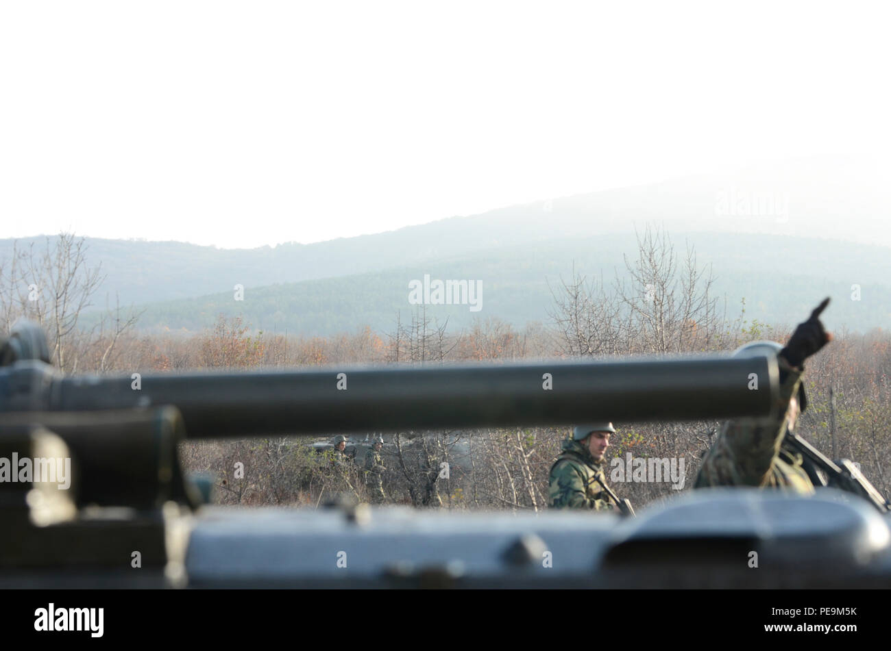 Una linea di soldati bulgara di 1-61st battaglione meccanizzato può essere visto sotto la canna di un Boyevaya Mashina Pekhoty 1 (BMP-1) come continuano l'approccio offensivo sul nemico durante la fase di esercizio la pace Sentinel a Novo Selo Training Center, Bulgaria, nov. 24, 2015. (U.S. Foto dell'esercito da Staff Sgt. Steven M. Colvin/rilasciato) Foto Stock