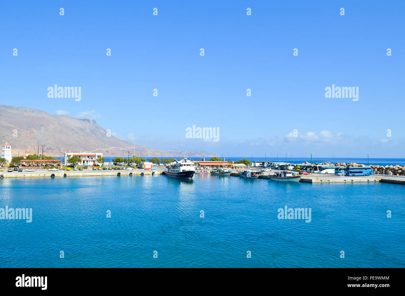 Un pontile in un piccolo porto greco al mattino presto. Imbarcazioni da diporto e gli autobus in un piccolo porto. Foto Stock