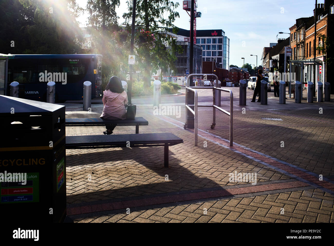 Raggio di luce nelle prime ore del mattino brilla in giù su un bus di attesa passeggero Foto Stock