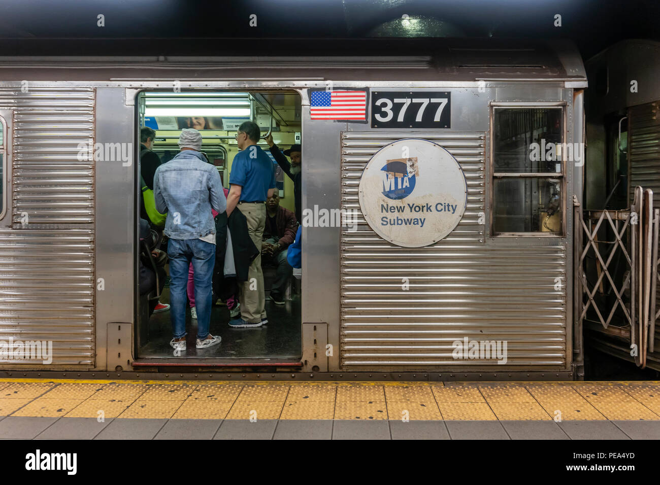 I passeggeri che viaggiano su un treno della metropolitana di New York City Foto Stock