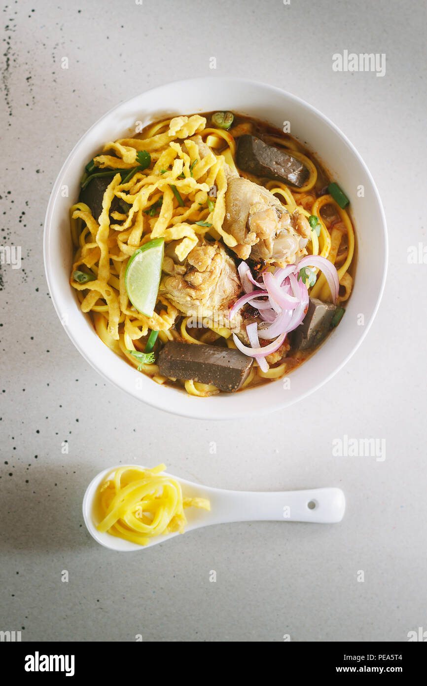 Salsa speziata zuppa di noodle (Khao soi) con latte di cocco, settentrionale della cucina tailandese,profondità di campo ridotta,concentrarsi sul pollo. Foto Stock
