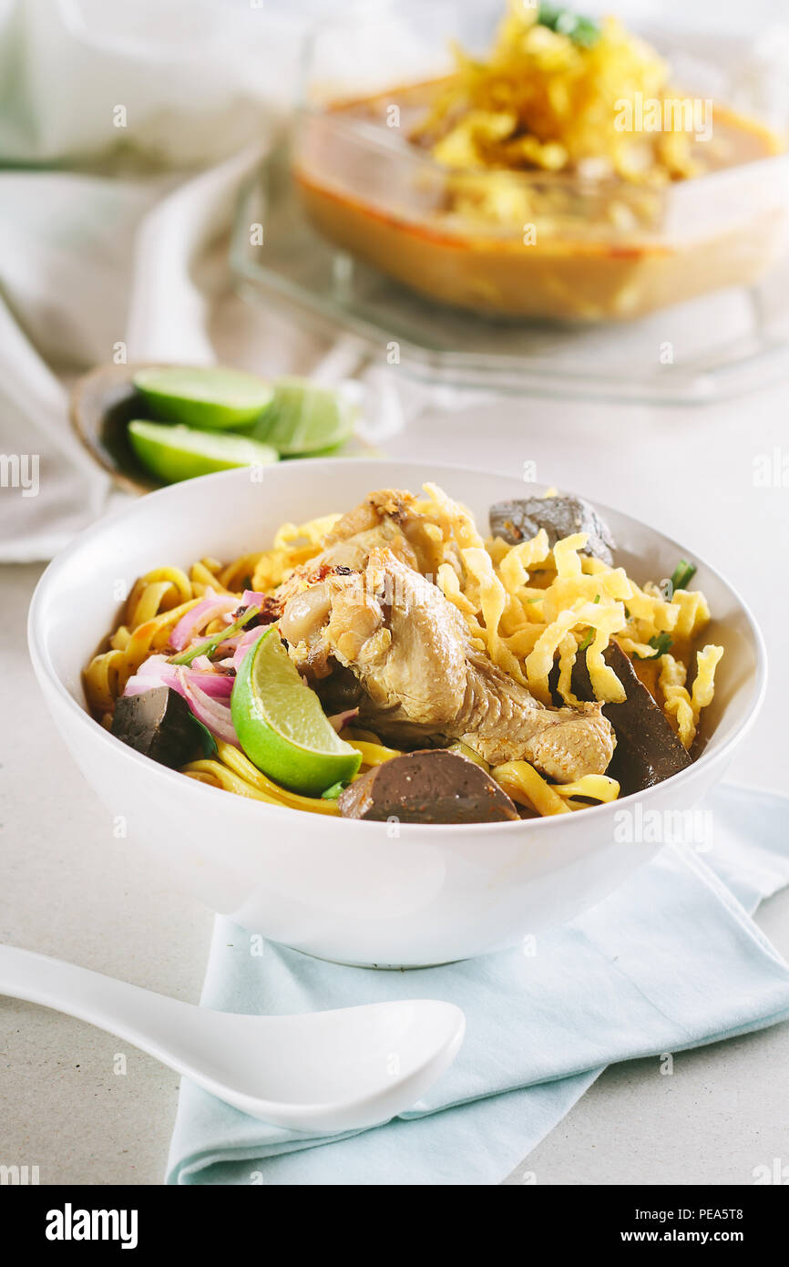 Salsa speziata zuppa di noodle (Khao soi) con latte di cocco, settentrionale della cucina tailandese,profondità di campo ridotta,concentrarsi sul pollo. Foto Stock