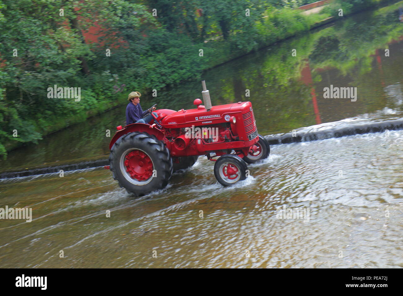 Funzionare il trattore che vede i trattori e altri veicoli attraversare il fiume in convoglio come loro capo in Ripon centro città da Newby Hall North Yorks. Foto Stock