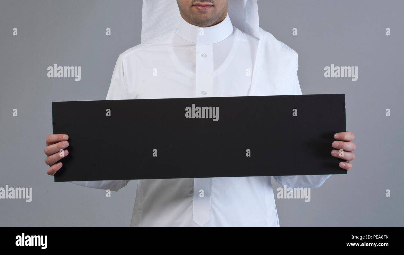 Sorridente Arabia uomo arabo di trattenimento di un nero vuoto segno bordo Foto Stock