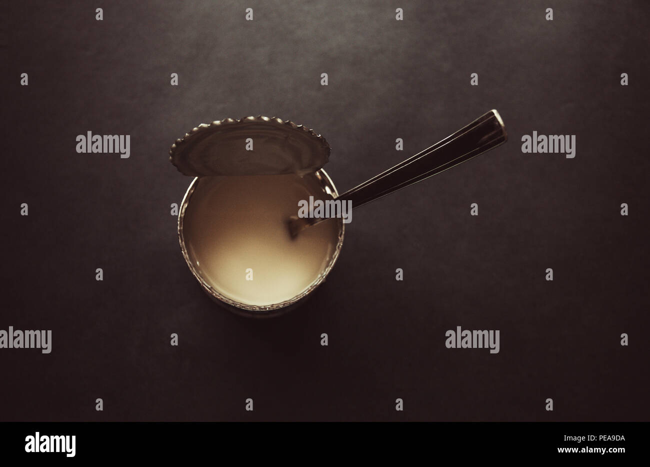 Stagno di ferro di latte condensato con cucchiaio su sfondo grigio,  immagine vintage Foto stock - Alamy