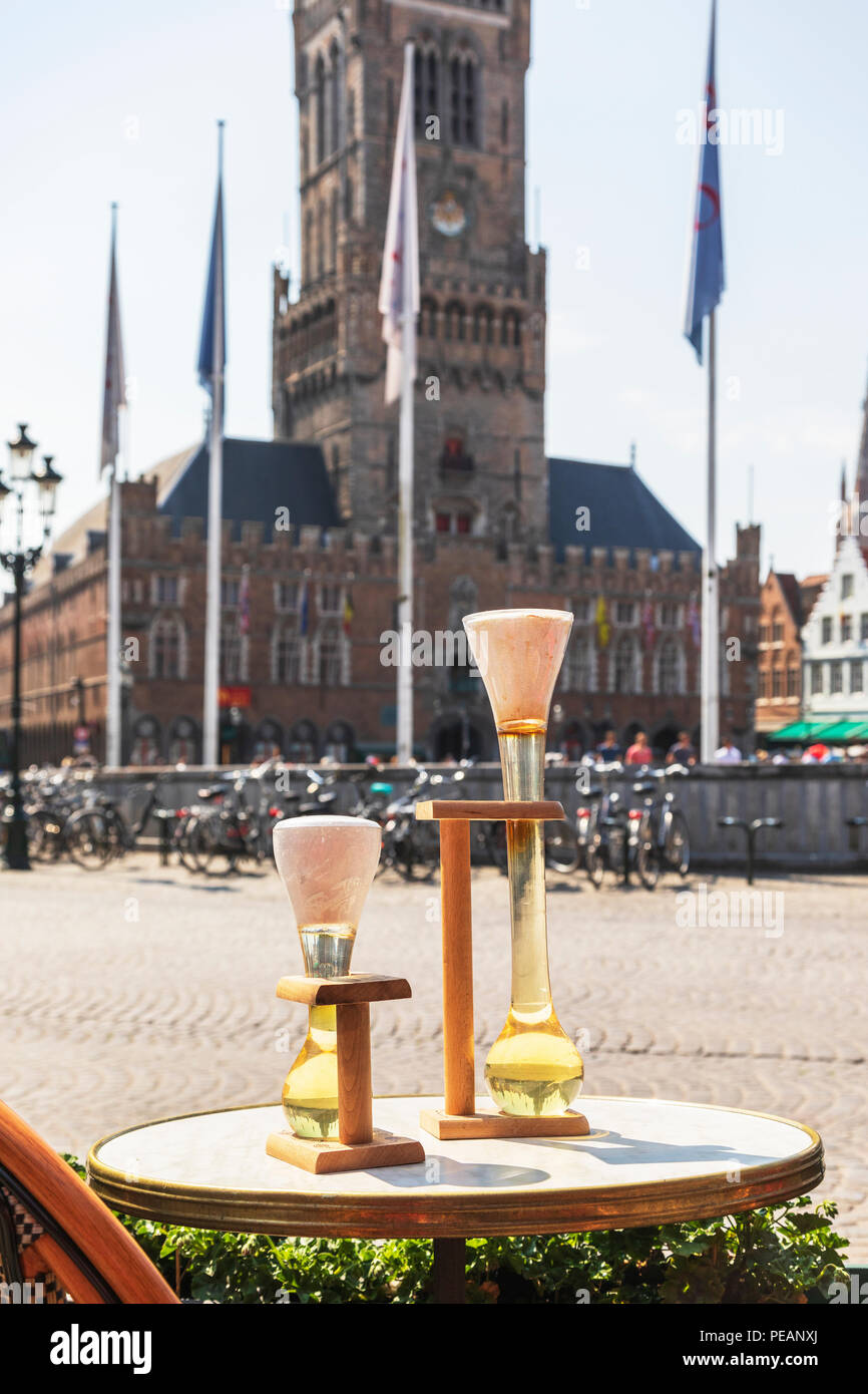 Decorazioni per la tavola la pubblicità della birra belga in un ristorante affacciato sul Markt e il XV secolo campanile di Bruges Bruges, Belgio Foto Stock