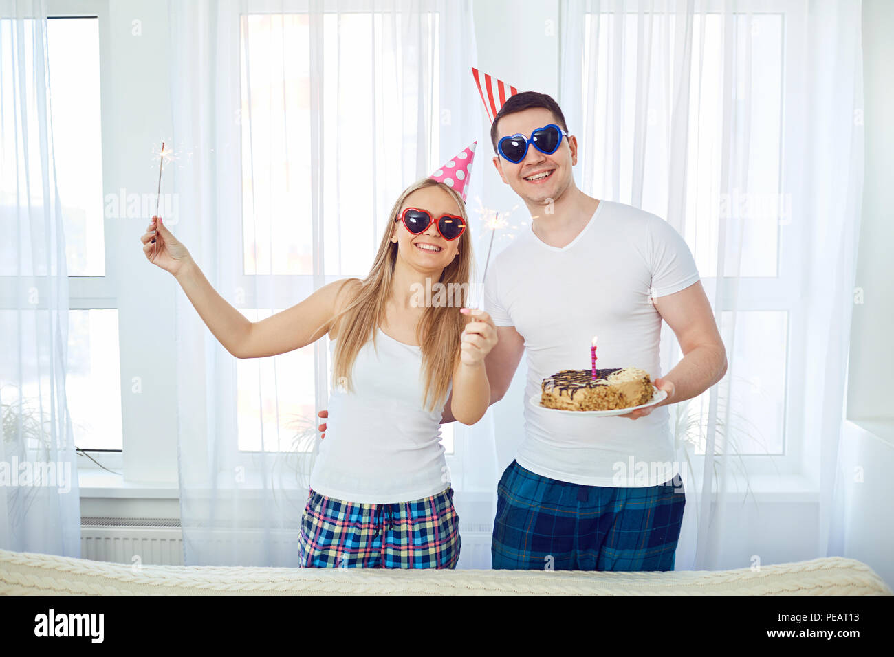 Giovane con una torta con le candele si congratula con il giorno del suo compleanno su Foto Stock