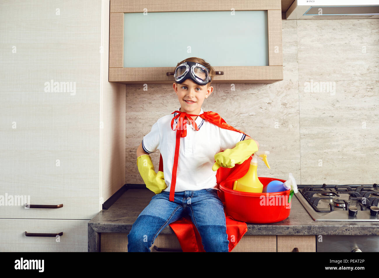 Un ragazzo vestito come un supereroe in cucina Foto Stock