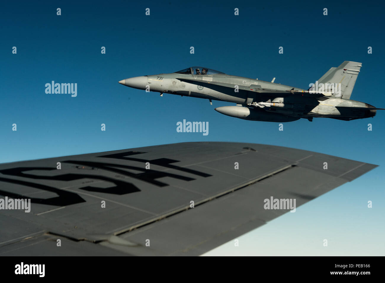 Un F-18 dal Royal Canadian Air Force vola accanto a U.S. Air Force KC-135 Stratotanker dal 340 Expeditionary Air Refuelling Squadron su Asia sud-ovest a sostegno di funzionamento inerenti risolvere, Dicembre 4, 2015. Funzione OIR è l'intervento della coalizione contro Daesh. (U.S. Air Force foto di Tech. Sgt. Nathan Lipscomb) Foto Stock