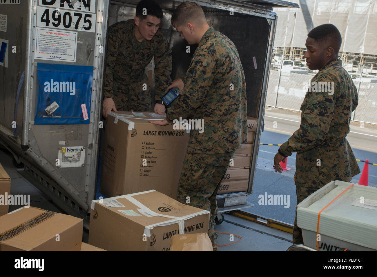 I Marines postali assegnati al quartier generale e al quartier generale Squadron presso la stazione aerea del corpo dei Marines di Iwakuni, Giappone, scaricano la posta durante le festività natalizie il 3 dicembre 2015. Le postazioni mobili di Postal Express consentono ai residenti della stazione di consegnare i pacchi e rispettare le scadenze del servizio postale degli Stati Uniti. I Marines garantiscono la consegna tempestiva della posta, mantengono il flusso di lavoro operativo e forniscono assistenza ai clienti gestendo al contempo volumi maggiori durante il periodo delle vacanze. Foto Stock